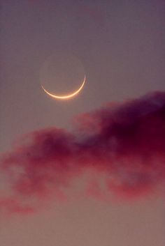 the crescent moon is seen through some clouds