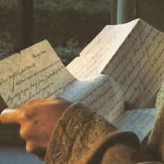 two people holding papers in their hands with writing on them, and one person is reading the paper