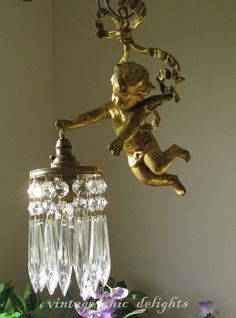 a chandelier hanging from the ceiling in a room with flowers and glass vases