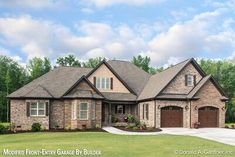 a large brick house with two garages and lots of grass in front of it