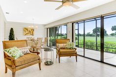 a living room filled with furniture next to a sliding glass door covered in plants and grass