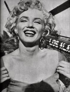 marilyn monroe laughing in front of an airplane