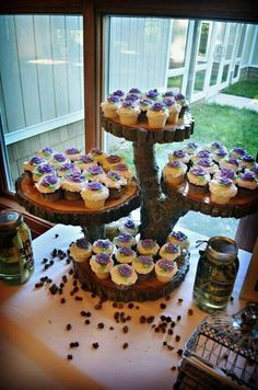 there are cupcakes that are on the cake stand in front of the window