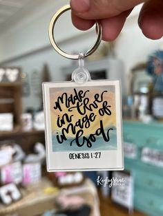 a hand holding a keychain with a bible quote on it