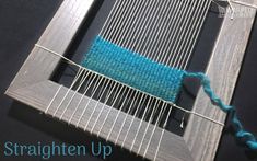 a close up of a weaving machine with blue yarn on the top and bottom of it