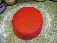 a red round cake sitting on top of a counter