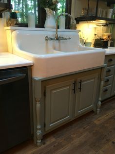 a kitchen sink sitting under a window next to a dishwasher