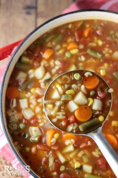 a pot full of vegetable soup with a spoon in it