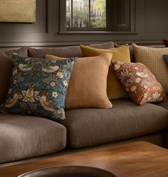 a brown couch with many pillows on it