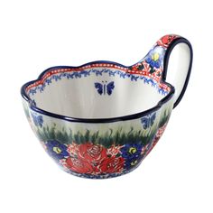 a bowl with flowers painted on it and a handle in the shape of a fish