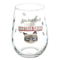 a wine glass with a grumpy cat face on it's side and the words, you look like i need another drink