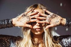 a woman covered in dirt covering her eyes and hands with both hands on top of her head