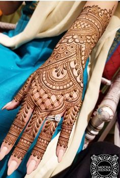 a woman's hand with henna tattoos on it