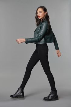 a woman in black leggings and a green leather jacket