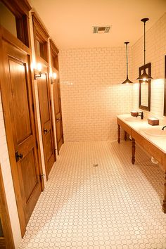 a bathroom with two sinks, mirrors and lights on the wall next to each other