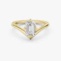 a yellow gold ring with an emerald cut diamond