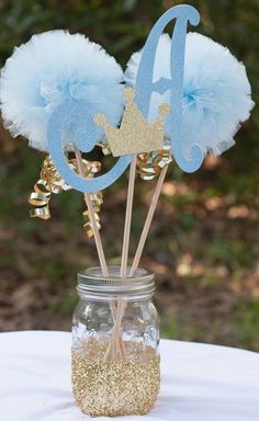 two blue and gold decorations in a mason jar