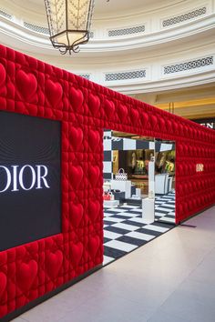 the interior of a luxury store with red and black wall covering it's entrance