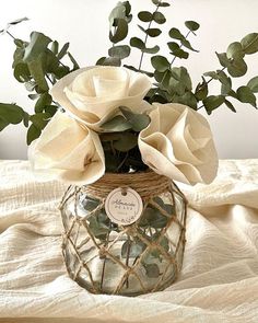 a vase filled with white flowers on top of a bed