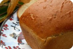 a loaf of bread sitting on top of a blue and white plate next to corn stalks