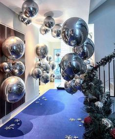 a hallway decorated for christmas with silver balls hanging from the ceiling