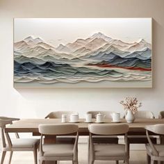 a dining room table with white chairs and a large painting on the wall above it