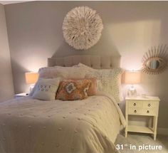 a white bed sitting in a bedroom next to two nightstands with lamps on them