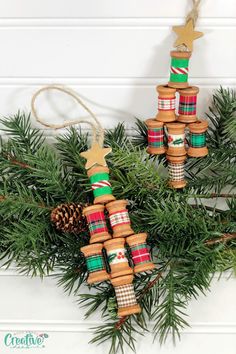 some christmas crackers are hanging from a tree with pine cones and plaid ribbon on them