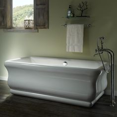 a large white bath tub sitting next to a window