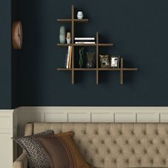 a living room with a couch, bookshelf and vases on the wall