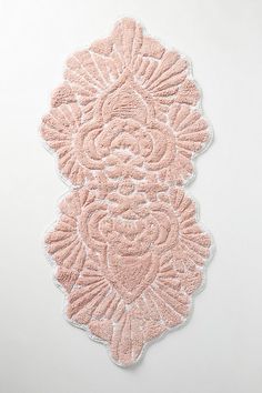 a pink doily with an intricate design on the front and back of it's edges