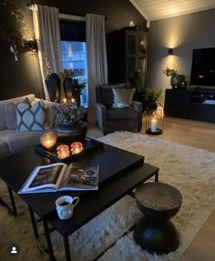 a living room filled with lots of furniture and candles on top of a coffee table