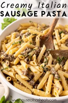 creamy italian sausage pasta in a white bowl with a wooden spoon and parsley on the side