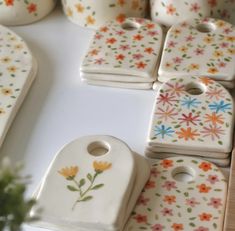 small ceramic dishes with flowers painted on them are arranged in a row and placed next to each other