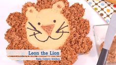 a lion cake with icing on it sitting next to a knife and some cookies