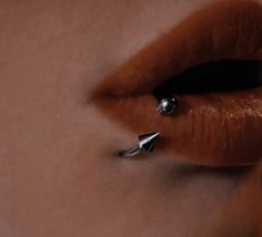 a woman's lips and nose piercings are seen in this artistic photograph from the waist up