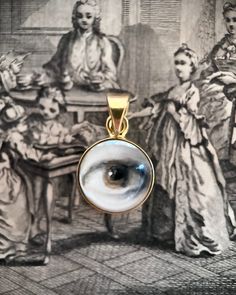 Lover's Eye pendant with an oil painting encased in gold plate over sterling with a quartz crystal cabochon which gives a magical magnifying effect, measuring 1/2" in diameter; 18" 16k gold over brass chain included. THE HISTORY: Lover's Eyes were a jewelry trend c.1785-1830 of brooches set with tiny watercolor portraits on ivory. Since they were cropped to eyes, they were in many ways more direct and intimate than traditional miniature portraits; but also because they were just eyes, they were Spiritual Gold Cabochon Necklace, Artistic Gold Jewelry With Cabochon, Gold Spiritual Necklace With Cabochon, Spiritual Gold Necklace With Cabochon, Artistic Gold Round Jewelry, Artistic Gold Jewelry With Large Pendant, Artistic Gold Necklace With Round Pendant, Gold Cabochon Round Pendant Jewelry, Unique Gold Necklace For Memorial