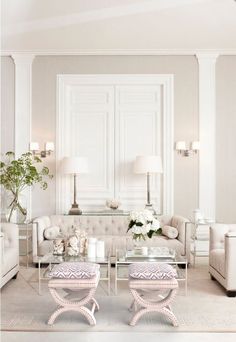 a living room filled with white furniture and lots of lamps on top of it's tables