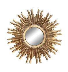 a gold sunburst mirror on a white wall