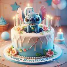 a blue birthday cake with candles on it and a small elephant figurine in the middle