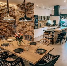 a dining room table and chairs in front of a brick wall with an oven on it