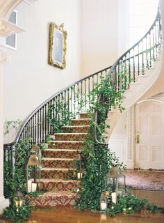 the stairs are decorated with greenery and lit candles for an elegant touch to the room