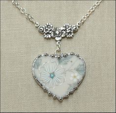 a heart shaped necklace with flowers on it