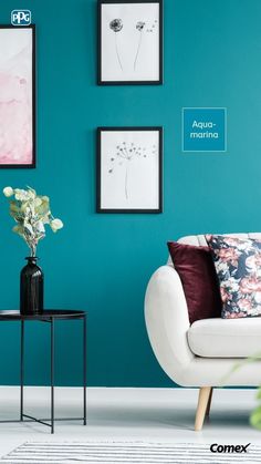 a living room with blue walls and pictures on the wall, including a white couch