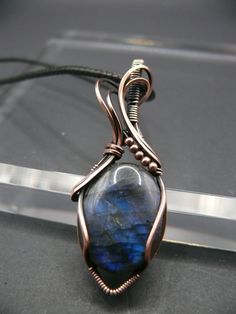 Handmade blue wire-wrapped labradorite gemstone pendant. Labradorite is known for its captivating play of colour, shifting hues from blues and greens to flashes of gold.  Labradorite activates intuition, wisdom, clarity, creativity, and divination it helps to recognize positivity and hope. Each pendant is a one-of-a-kind piece of wearable art, making it the perfect statement accessory for those who appreciate the extraordinary.  This beautiful gemstone is wrapped in oxidized copper to give it a Blue Labradorite Wire Wrapped Jewelry, Copper Jewellery, Wire Wrapping Diy, Oxidized Copper, Art Making, Blue Labradorite, Wrapped Jewelry, Interesting Stuff, Wire Wrapped Jewelry