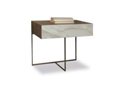 a white marble side table with metal legs and two books on it's top