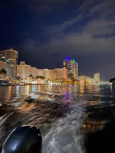 the city lights shine brightly in the distance as seen from a boat on the water