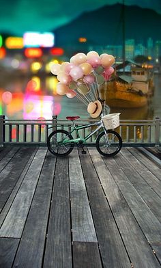 a bicycle with balloons attached to the handlebars is parked on a wooden deck