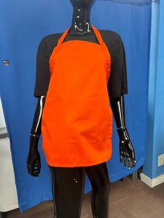 the mannequin is wearing an orange apron