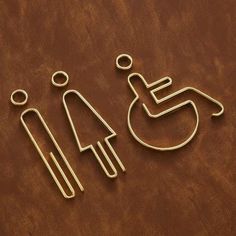 two pieces of metal wire sitting next to each other on a brown surface with one person in a wheelchair